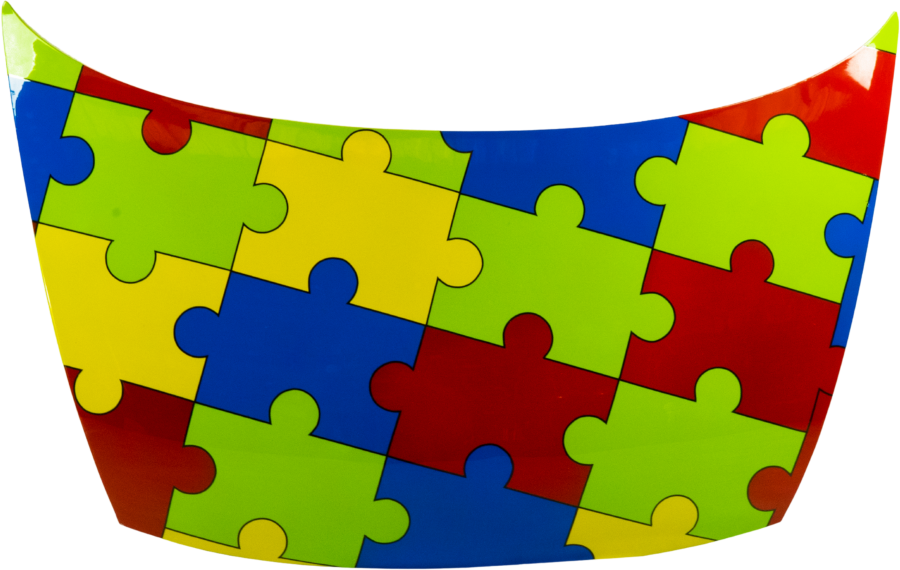 A car hood painted with a green, blue, red and yellow jigsaw pattern by a TVET student